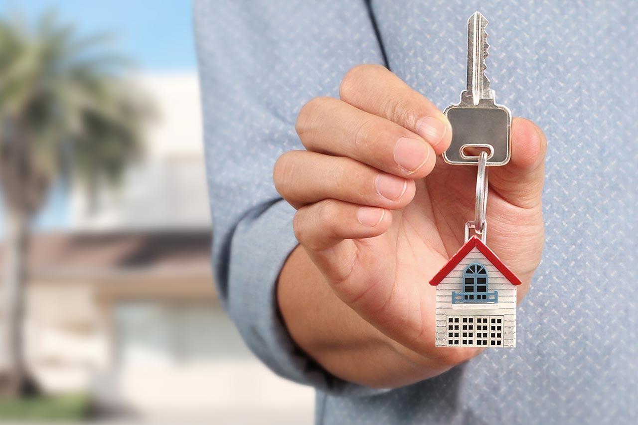 Young male college student showing off the keys to his new kiddie condo.