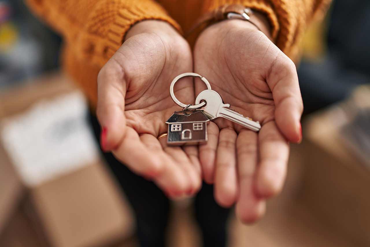 Two hands holding the keys to a newly purchased property.