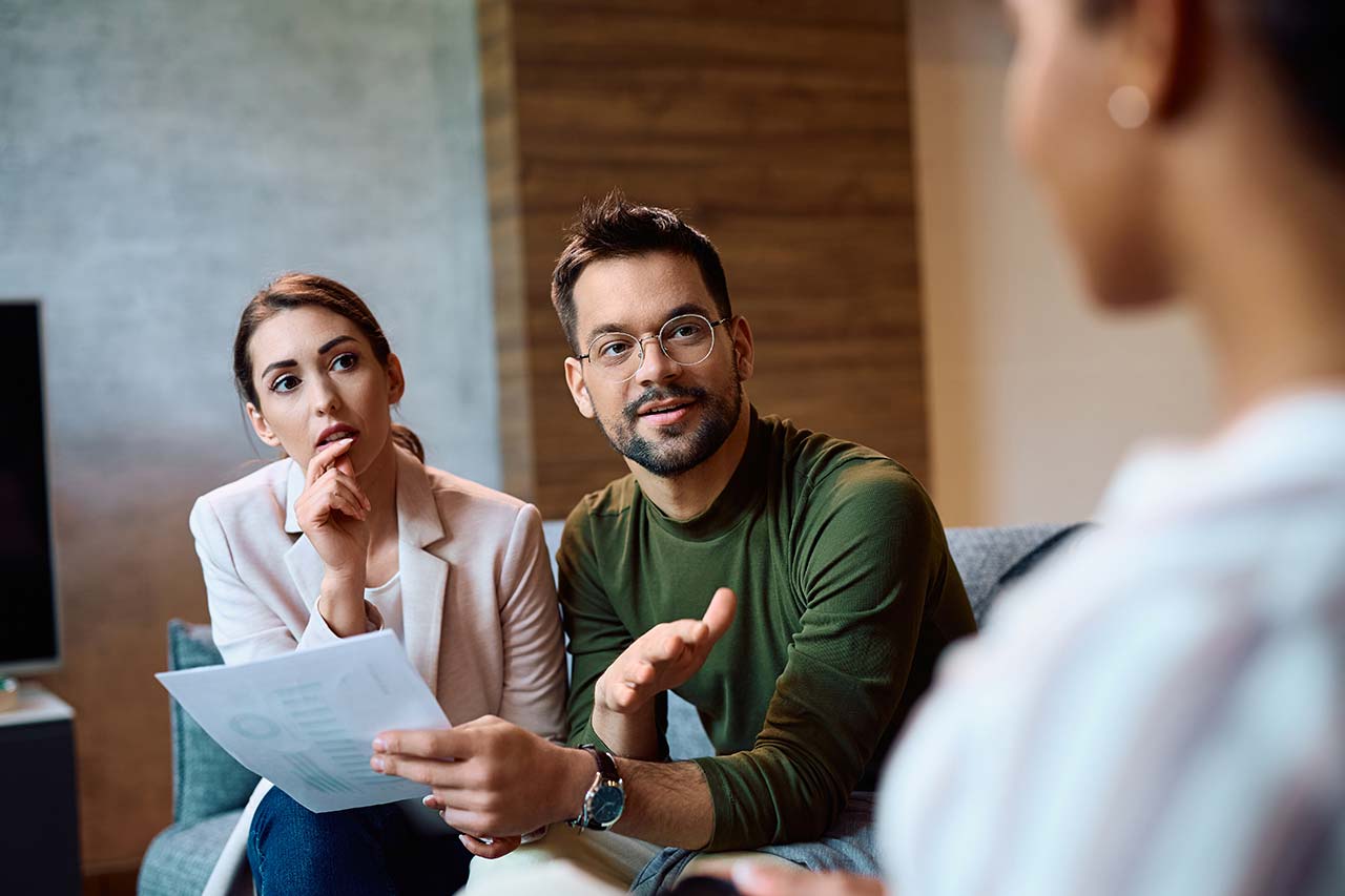Young couple discussing credit scores with their loan officer.