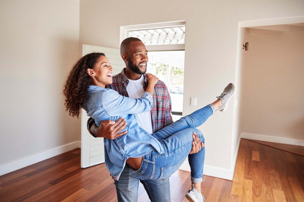Couple reviewing mortgage options and home-buying numbers on a laptop in their kitchen, preparing for a Phoenix Metro purchase.
