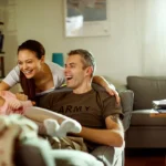 Veteran relaxing at home with partner and baby, representing a primary-residence VA loan purchase goal